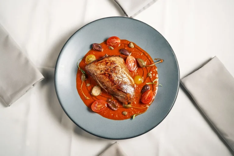 Filet de poisson blanc en sauce tomate dans une assiette