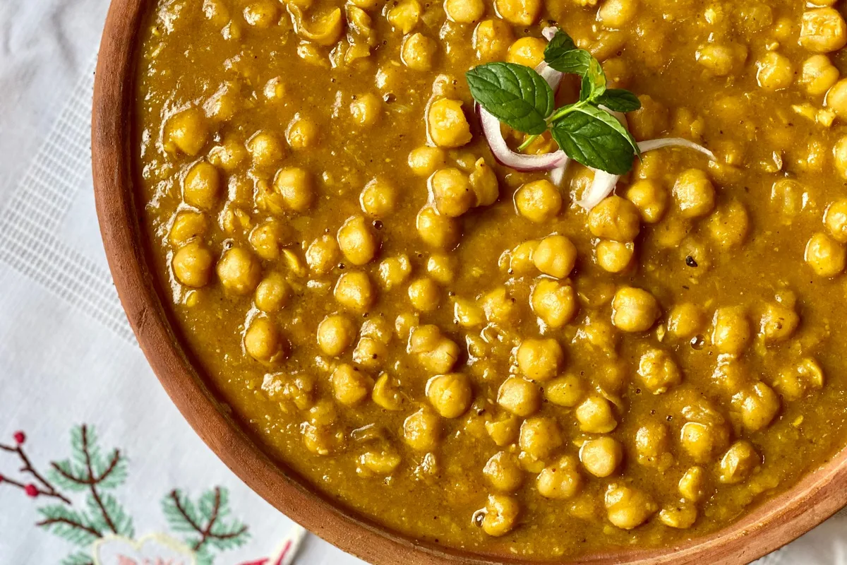 Curry de pois chiches dans un bol en bois, feuille de menthe