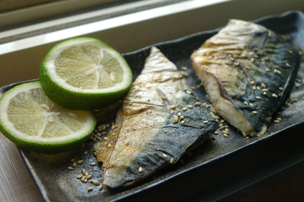 Maquereaux grillés sur un plat avec des rondelles de citron vert