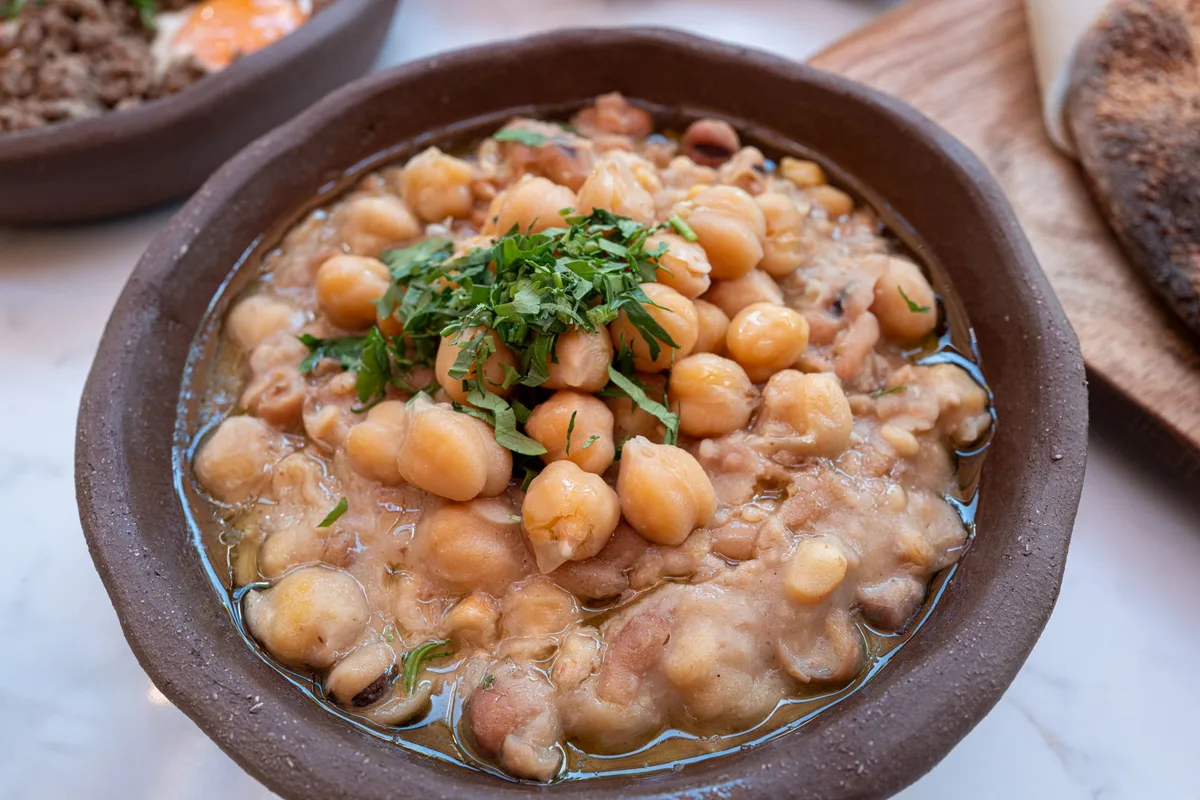 Haricots blancs mijotés aux herbes dans un plat en terre