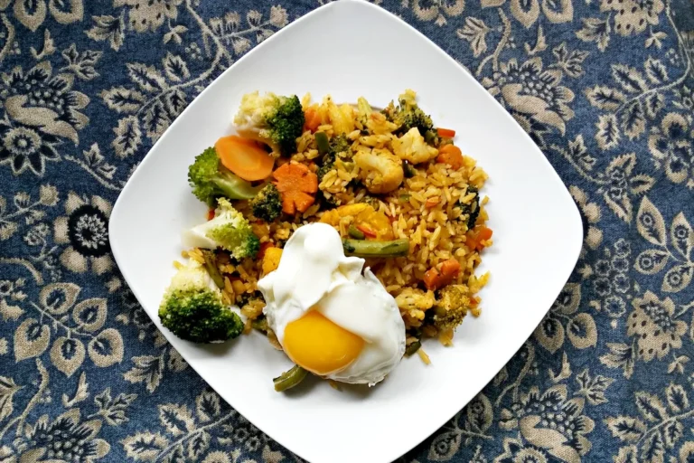Riz sauté aux légumes et œuf poché dans une assiette