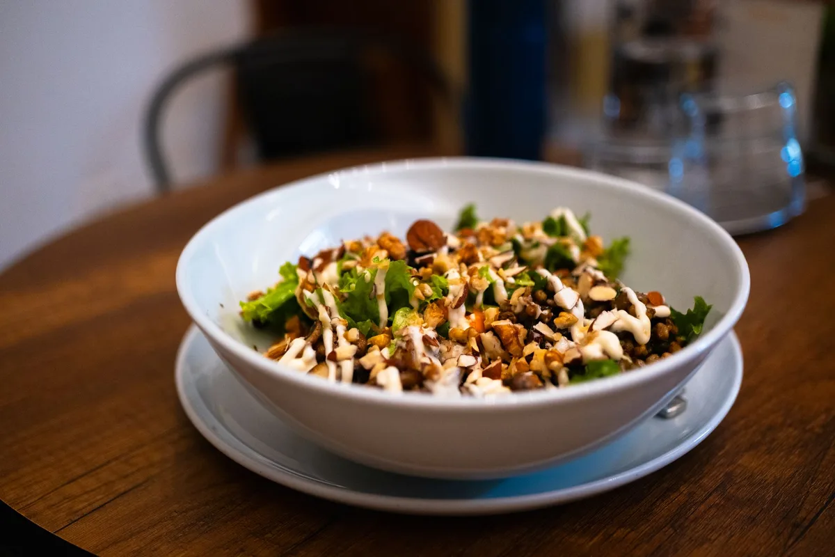 Salade de lentilles et graines servie dans un bol blanc