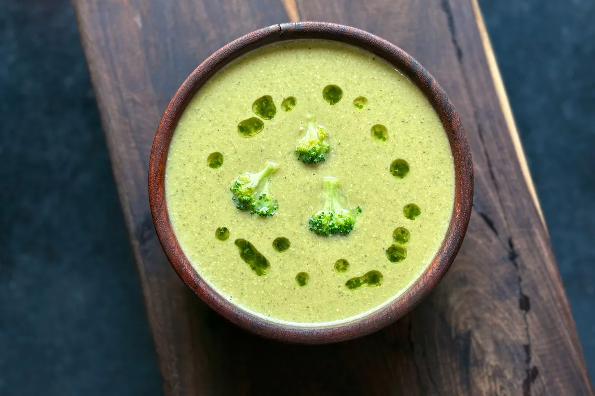 Velouté vert de brocoli dans un bol sur une planche